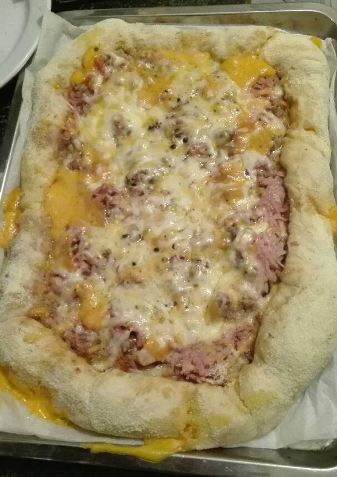 Una foto de Pizza de pollo y jamón york con los bordes relleno de queso cheddar