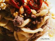 Una foto di pasta con carne di manzo