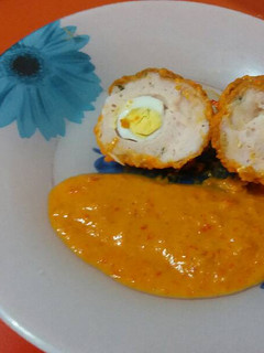 Una foto de Huevos a la escocesa en salsa de pimientos rojos