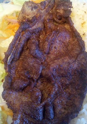Una foto de Bistekc con ensalada de lechuga y pepinillos