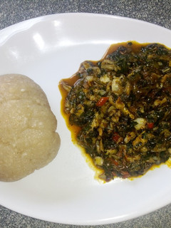 A picture of Eba and bitter leaf soup.