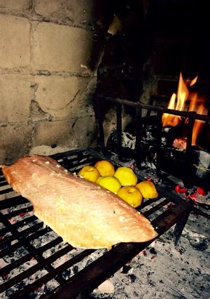 Una foto de Salmón a la leña con duraznos quemados