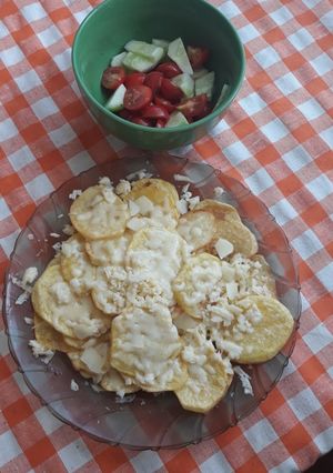 O poză a rețetei Cartofi felii cu brânză și salată de crudități.