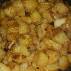A picture of Fried potatoes with onions.