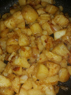 A picture of Fried potatoes with onions.