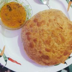 A picture of Aalo jhol wth daal kachori.
