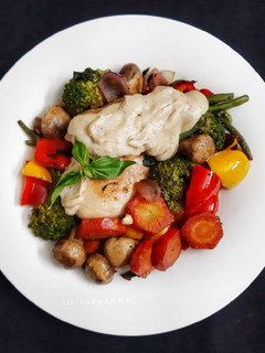 A picture of Olive oil & Butter Poached Chicken with veggies in white sauce.