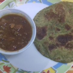 A picture of Methi ke parathe with aloo matar gravy.