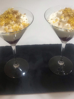 Una foto de Mousse de limón con mermelada de arándanos y crujiente de nueces y ralladura de limón
