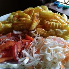 A picture of Potatoes wedges with cabbage salad and tomatoes salad (kachumbari)🥗.