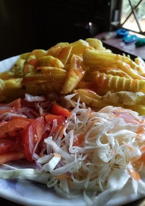A picture of Potatoes wedges with cabbage salad and tomatoes salad (kachumbari)🥗.