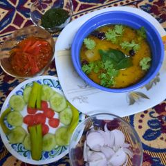 A picture of Tasty pumpkin lentils with pickle,salad and chutney.