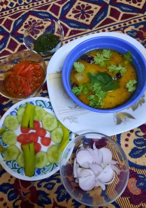 A picture of Tasty pumpkin lentils with pickle,salad and chutney.