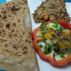 A picture of Half fry egg and mixed vegetables egg with paratha.