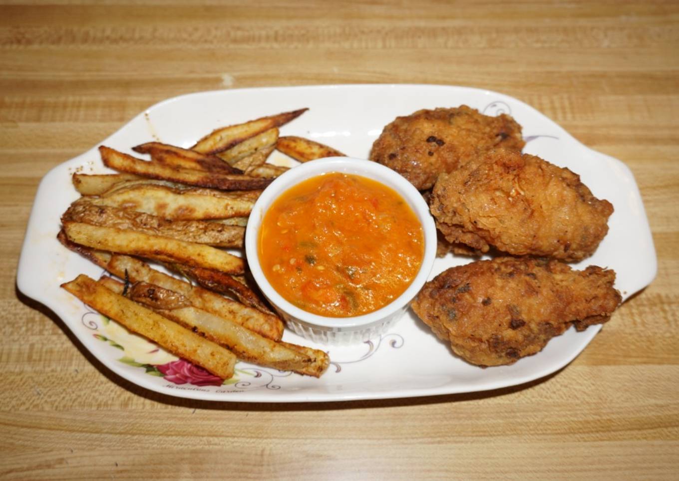 Fried chicken wings, french fries with rosemary, spices. John Styles