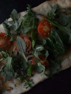 Una foto de Coca de tomate cherry y rúcula