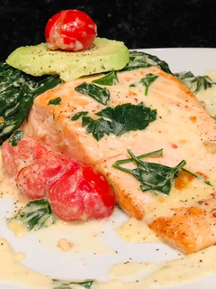 Una foto de Salmón al ajillo con Espinacas Baby y Tomates Cherries en crema de Queso Azul