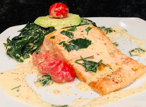 Una foto de Salmón al ajillo con Espinacas Baby y Tomates Cherries en crema de Queso Azul