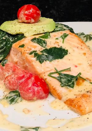Una foto de Salmón al ajillo con Espinacas Baby y Tomates Cherries en crema de Queso Azul