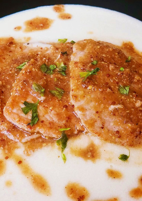 Una foto de Lomo en salsa de mostaza y miel sobre parmentier de patata y queso curado de oveja