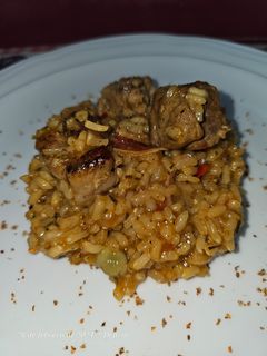 Una foto de Arroz con costillas adobadas con chimichurri, habitas, papada y tocineta