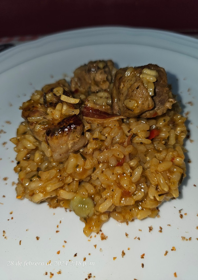 Una foto de Arroz con costillas adobadas con chimichurri, habitas, papada y tocineta