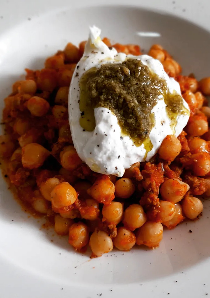 Una foto de Garbanzos a la boloñesa al comino con burrata y pesto