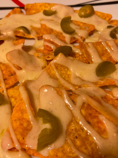 Una foto de Nachos con queso raclette y pepinillos