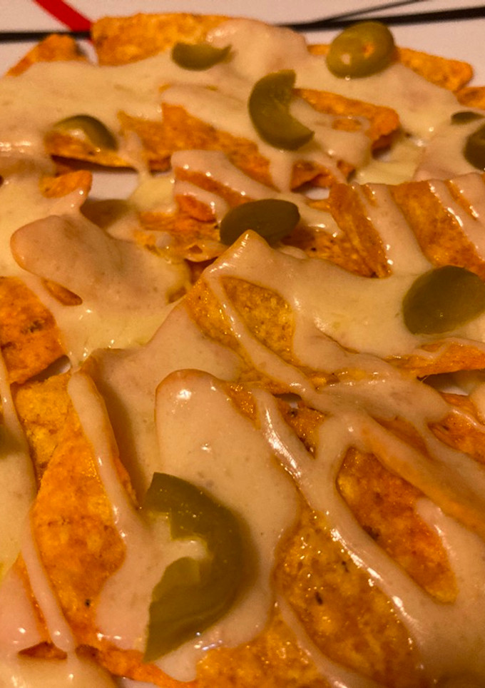 Una foto de Nachos con queso raclette y pepinillos