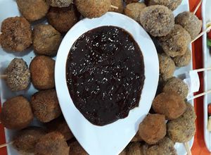 Una foto de Albóndigas  fritas acompañadas de salsa bbq