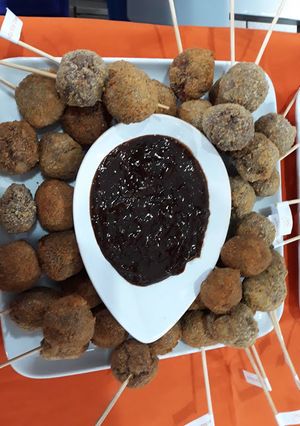 Una foto de Albóndigas  fritas acompañadas de salsa bbq