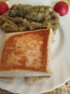 Una foto de Piadina o tortillas mexicanas rellena de pollo y queso en sartén