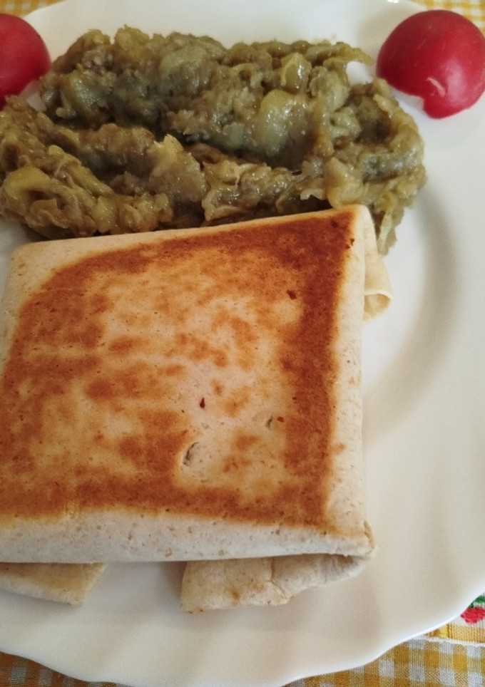 Una foto de Piadina o tortillas mexicanas rellena de pollo y queso en sartén