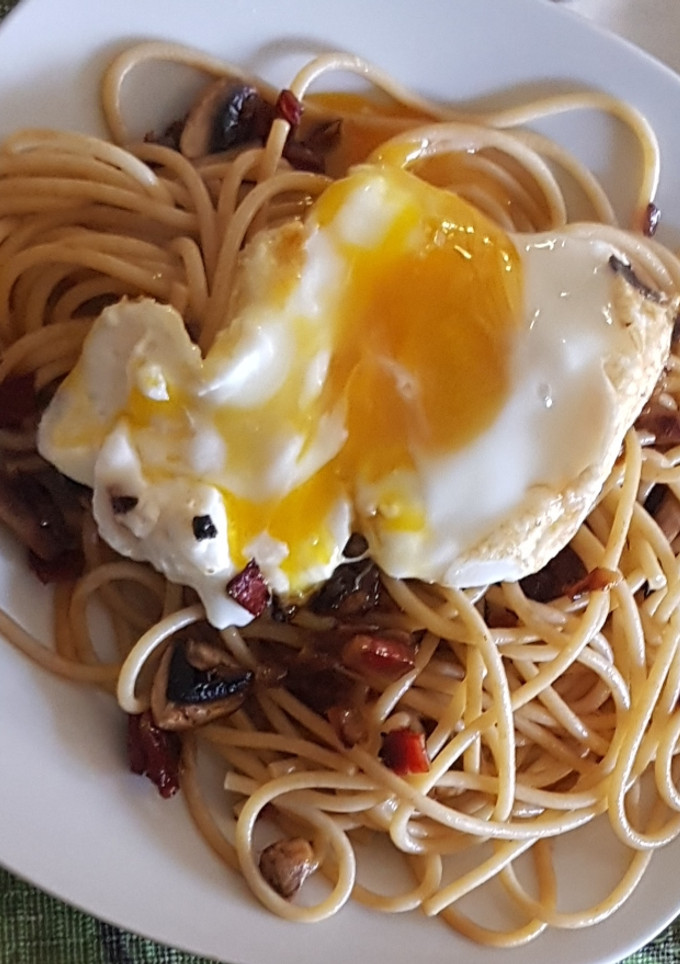 Una foto de Espaguetis integrales con jamón serrano, champiñones y huevo