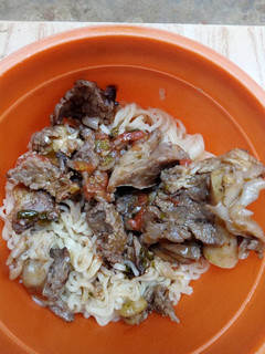 A picture of Beef stew and noodles.