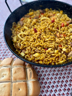 Una foto de Fideuà con atún rojo y gambita ”rota”