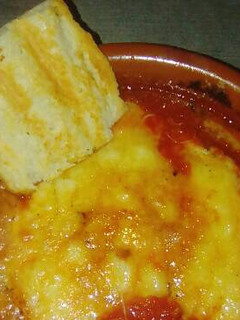 Una foto de Cazuelita de fondue de provolone y tomate triturado