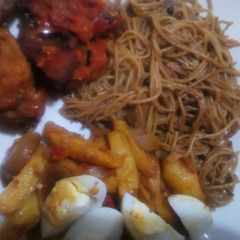 A picture of Brown spaghetti with sauteed potatoes and peppered chicken.