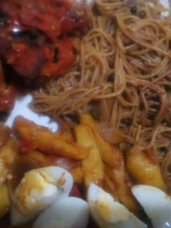 A picture of Brown spaghetti with sauteed potatoes and peppered chicken.