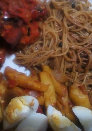A picture of Brown spaghetti with sauteed potatoes and peppered chicken.
