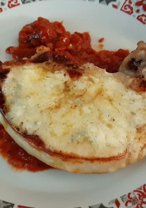 Una foto de Chuleta de cerdo con salsa de tomate y queso gorgonzola