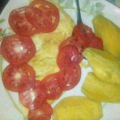 A picture of Fried eggs,boiled sweet potatoes and tomatoe.