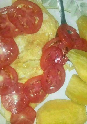 A picture of Fried eggs,boiled sweet potatoes and tomatoe.