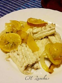 Una foto de Lubina al horno con cama de patatas y cebolla