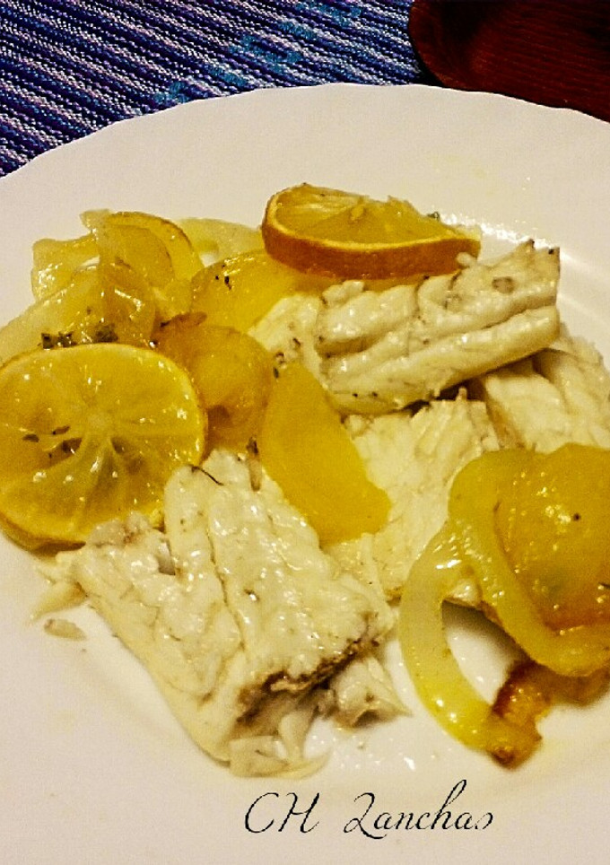 Una foto de Lubina al horno con cama de patatas y cebolla