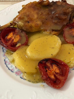 Una foto de Pollo al horno con patatas panaderas y tomate asado