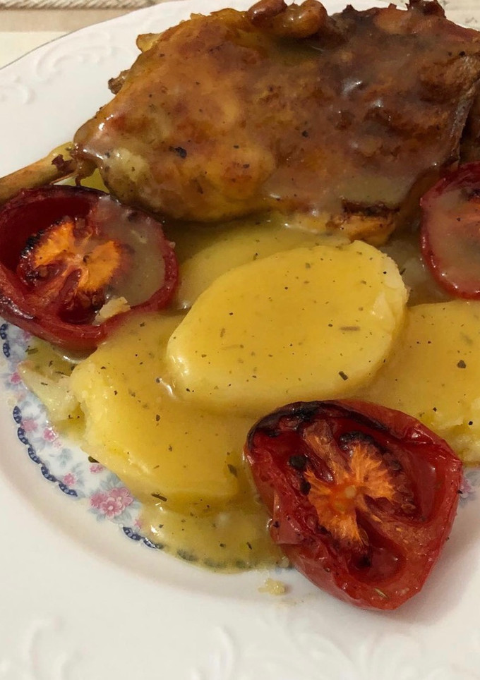 Una foto de Pollo al horno con patatas panaderas y tomate asado