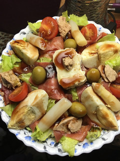 Una foto de Ensalada con paté de pato y queso de cabra con jamón y con crema de frambuesa