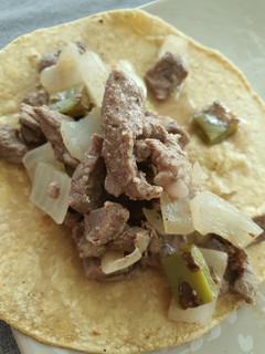 Una foto de Taquitos de Res, cebolla y nopales