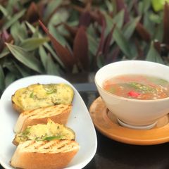 A picture of Thai vegetables soup with baked cheesy potatoes.